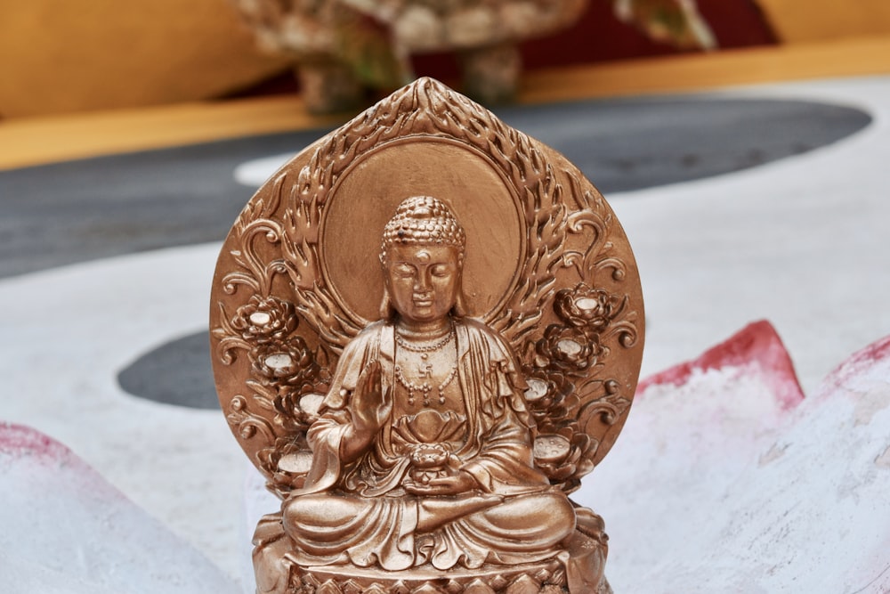 gold buddha figurine on white table
