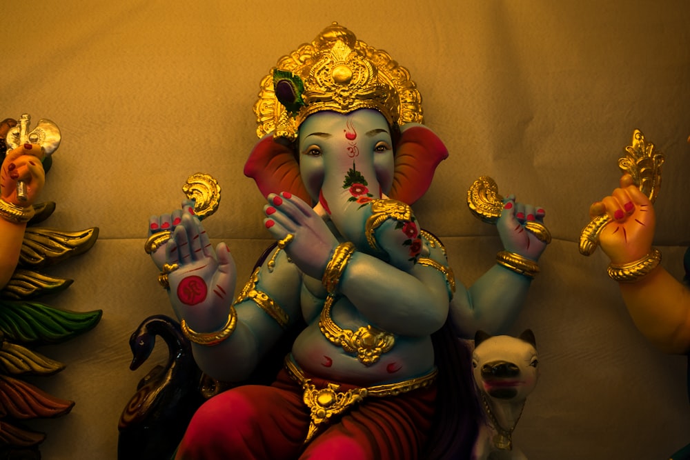 hindu deity figurine on red textile