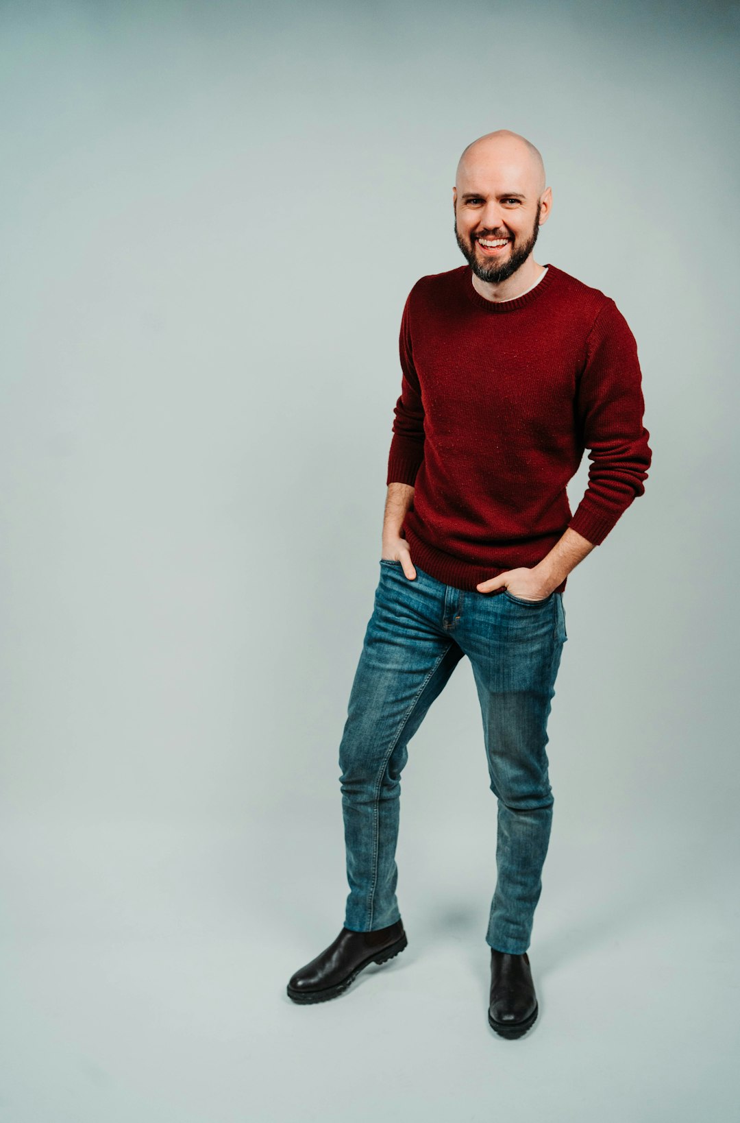 man in red sweater and blue denim jeans