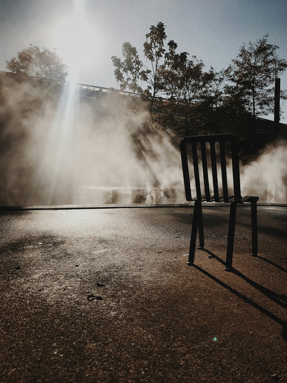 black wooden bench on gray sand during daytime