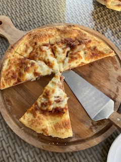 A vibrant display of pizzeria tools including pizza cutters and peelers on a rustic table