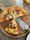 A rustic kitchen scene featuring a Viking-style pizza cutter resting on a wooden board with fresh pizza slices.