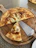 A rustic kitchen scene featuring a Viking-style pizza cutter resting on a wooden board with fresh pizza slices.
