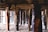 Wooden support beams under a pier are visible, providing a view of the sandy ground beneath. The beams vary in color and texture, with some showing signs of wear and watermarks.