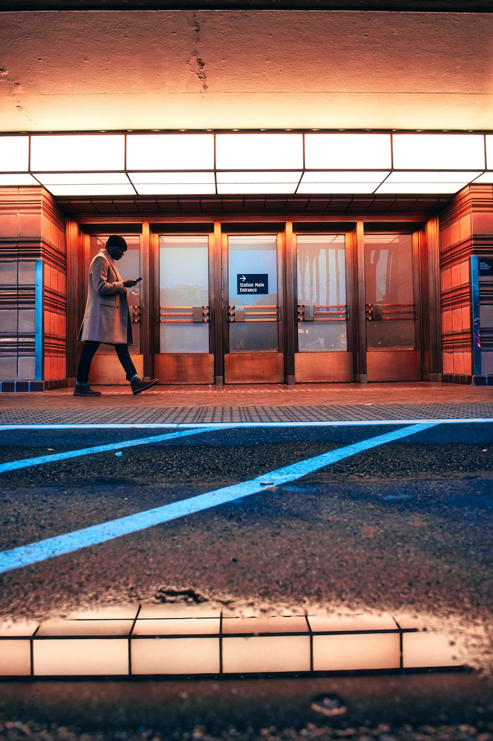 woman in black jacket walking on sidewalk during daytime