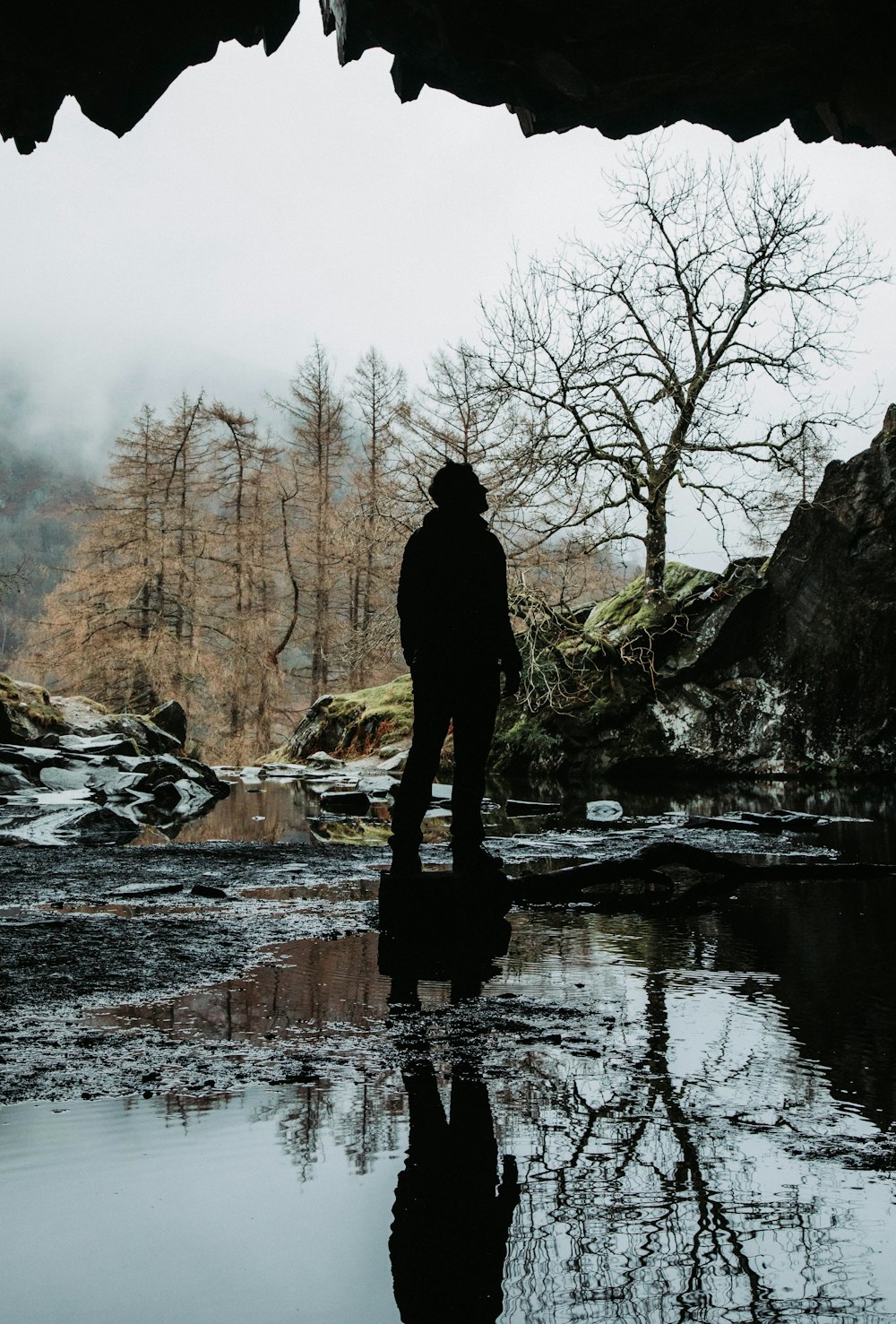 person standing on rock in river