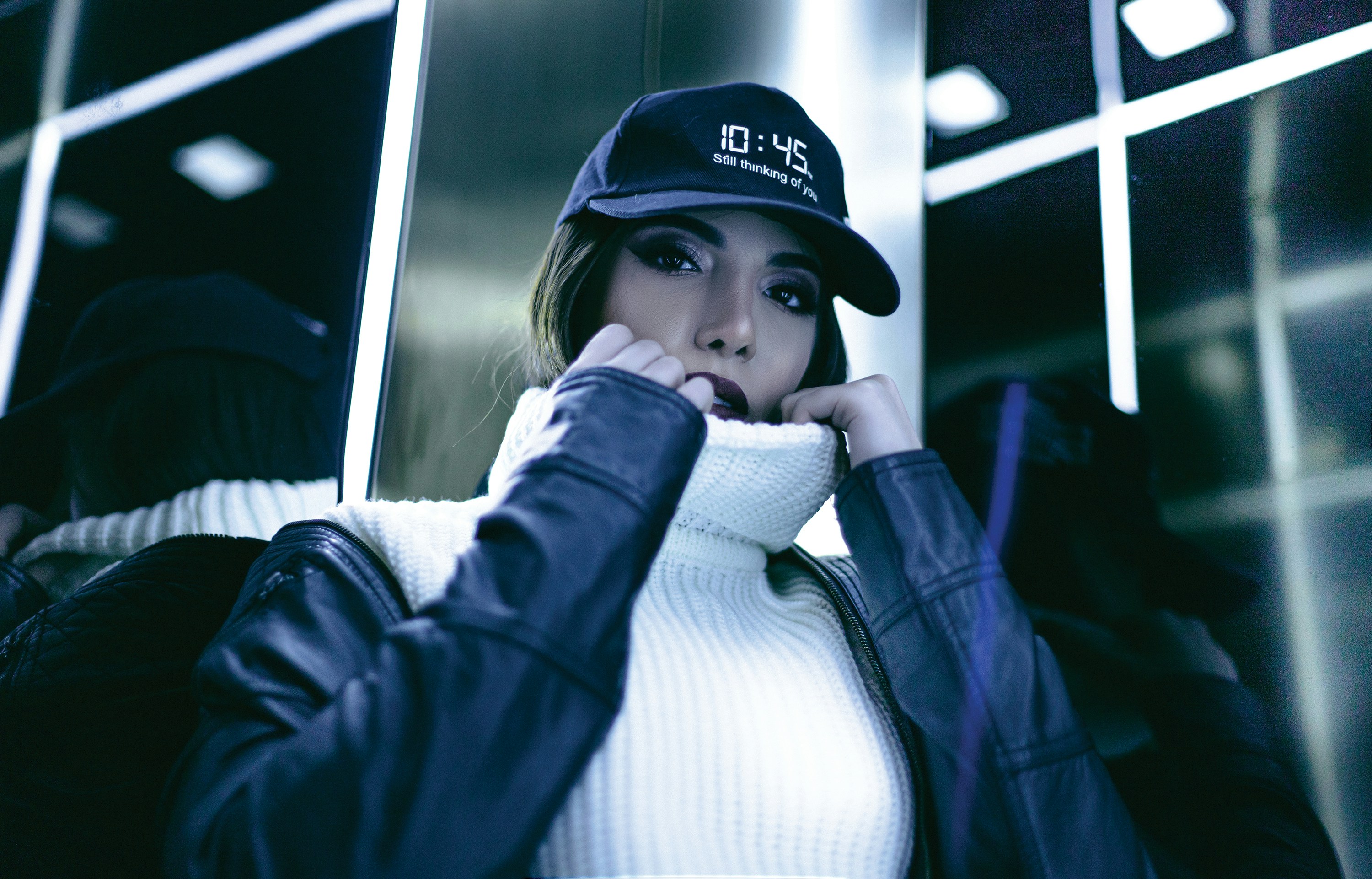 woman in blue jacket wearing white and black fitted cap