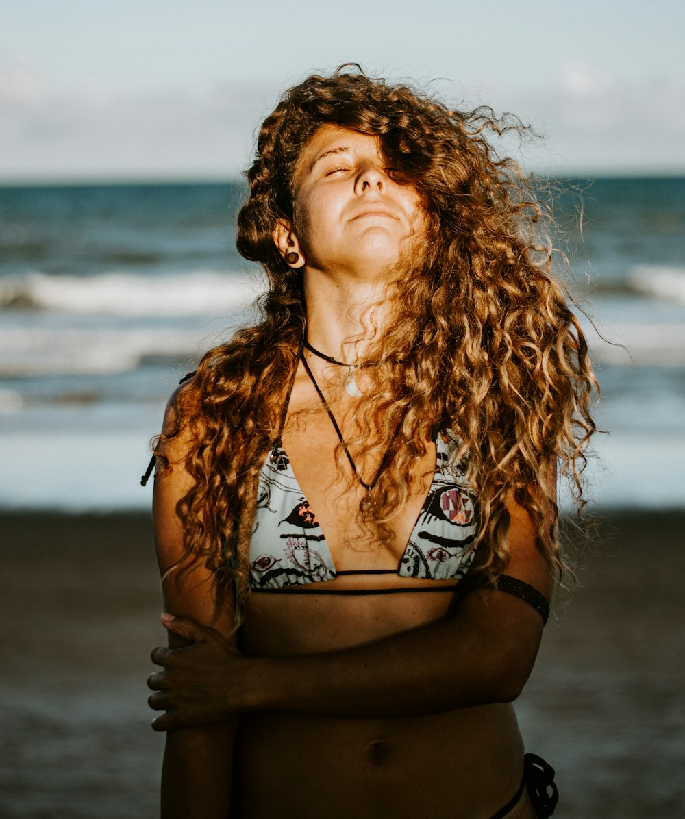 woman in black and white bikini top standing on beach during daytime