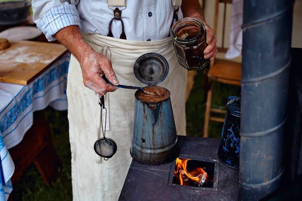 person holding stainless steel cooking pot