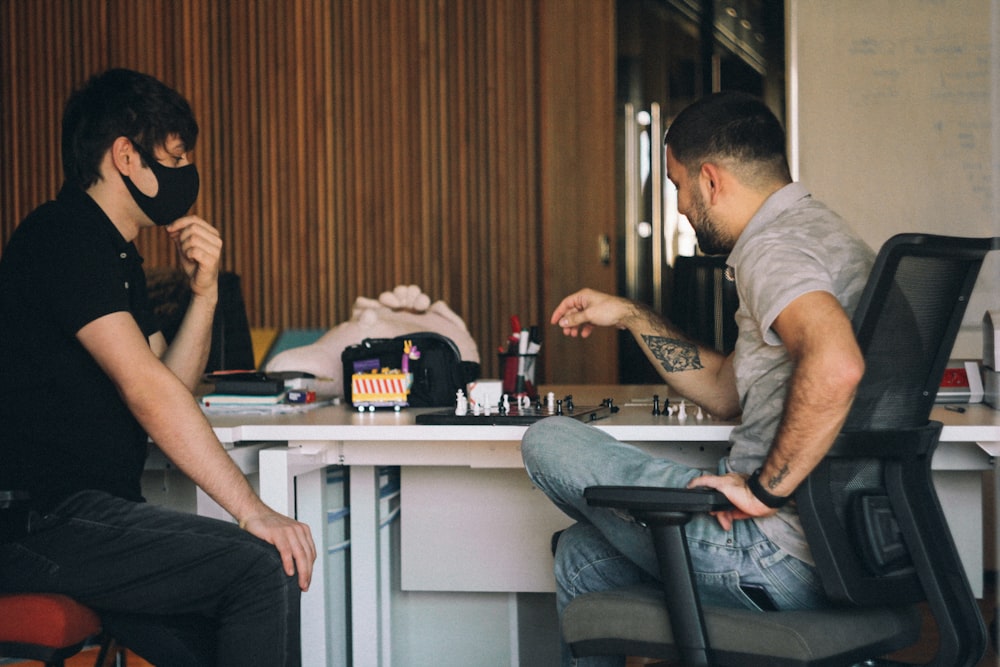 man in gray crew neck t-shirt sitting on black office rolling chair