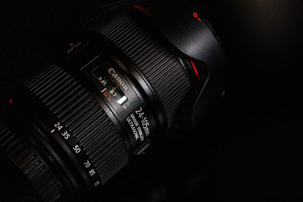 black canon camera lens on black surface