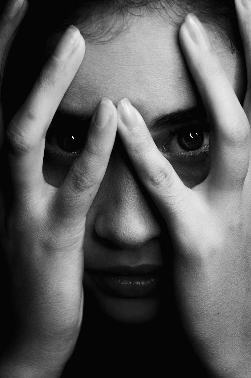 grayscale photo of woman covering her face