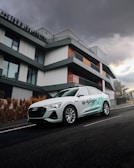 A sleek electric SUV parked in front of a modern glass building.