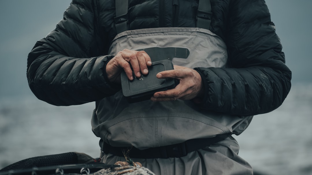 person in black jacket holding black smartphone