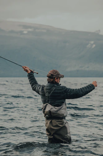 fly fisherman casting on the water