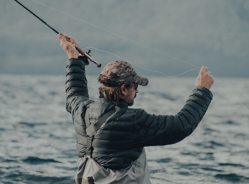 man in black jacket fishing during daytime