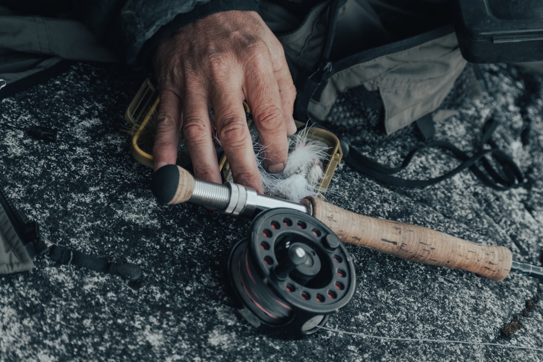 person holding silver and yellow hand tool