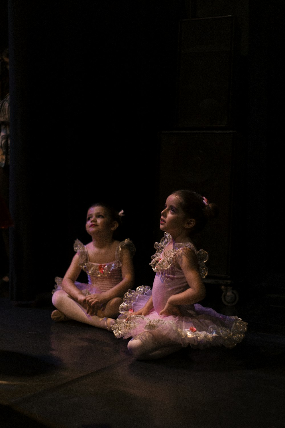 2 girls in pink dress sitting on floor