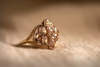 gold diamond studded ring on white textile
