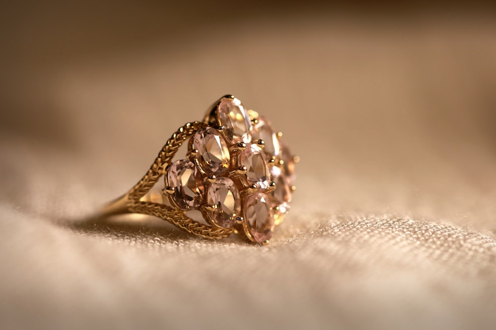 gold diamond studded ring on white textile