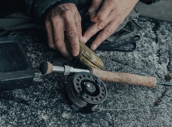 Technician fixing a spinning reel with precision tools