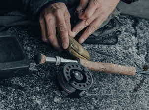 Technician fixing a spinning reel with precision tools