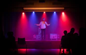 man in black shirt singing on stage