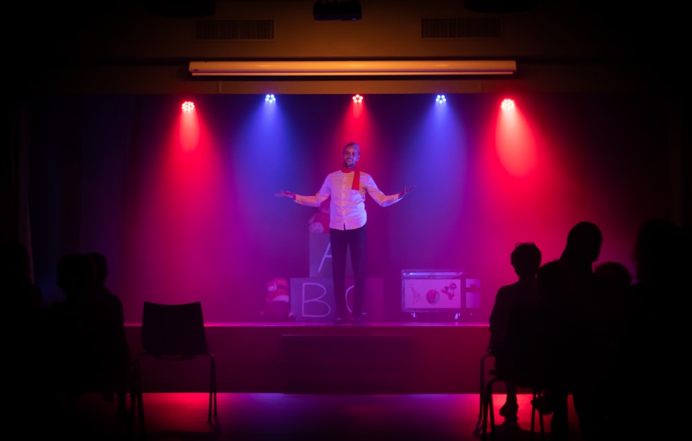 man in black shirt singing on stage