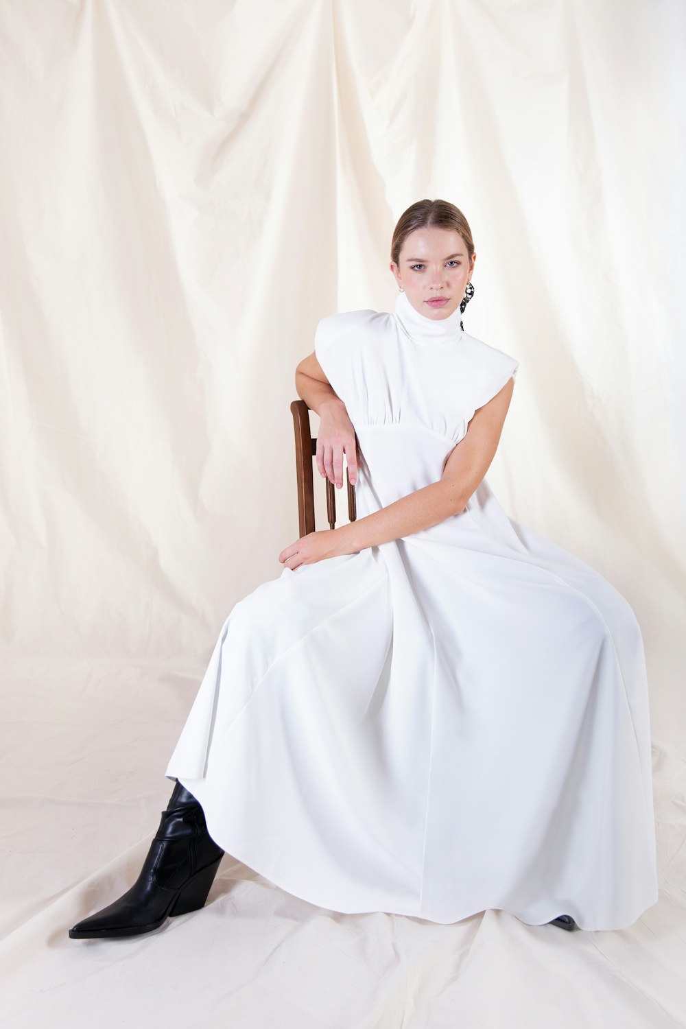woman in white dress sitting on brown wooden chair