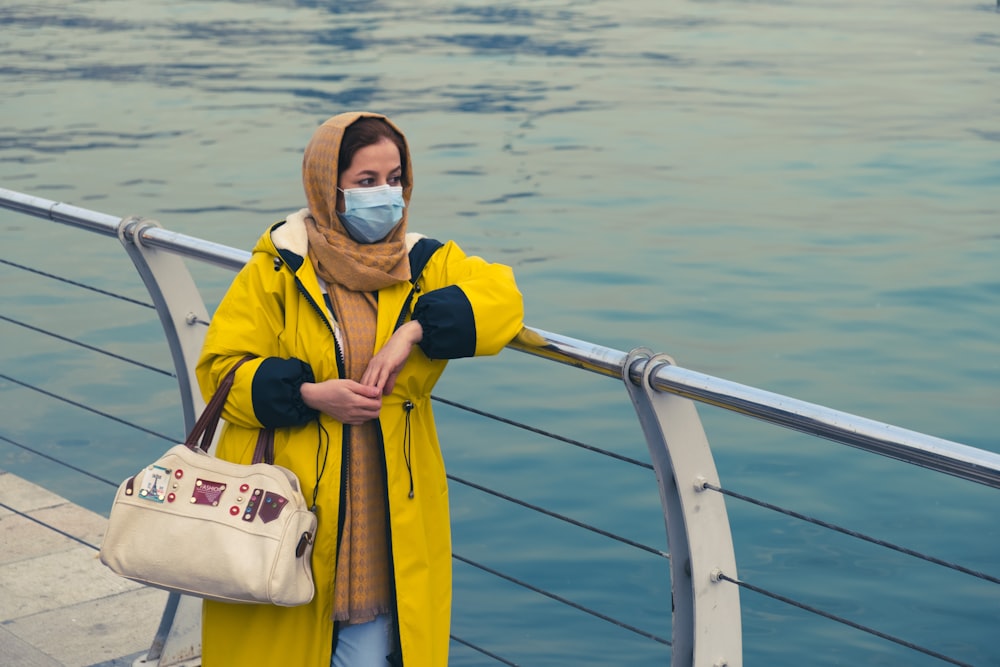 Homme en veste jaune et blanche portant des lunettes bleues debout sur le bateau pendant la journée