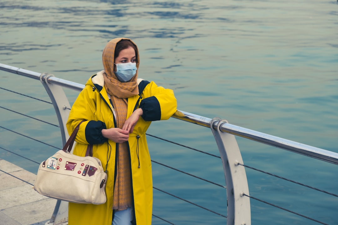 man in yellow and white jacket wearing blue goggles standing on boat during daytime