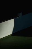 Artistic capture of shadows and light playing on a smooth, white wall surface.