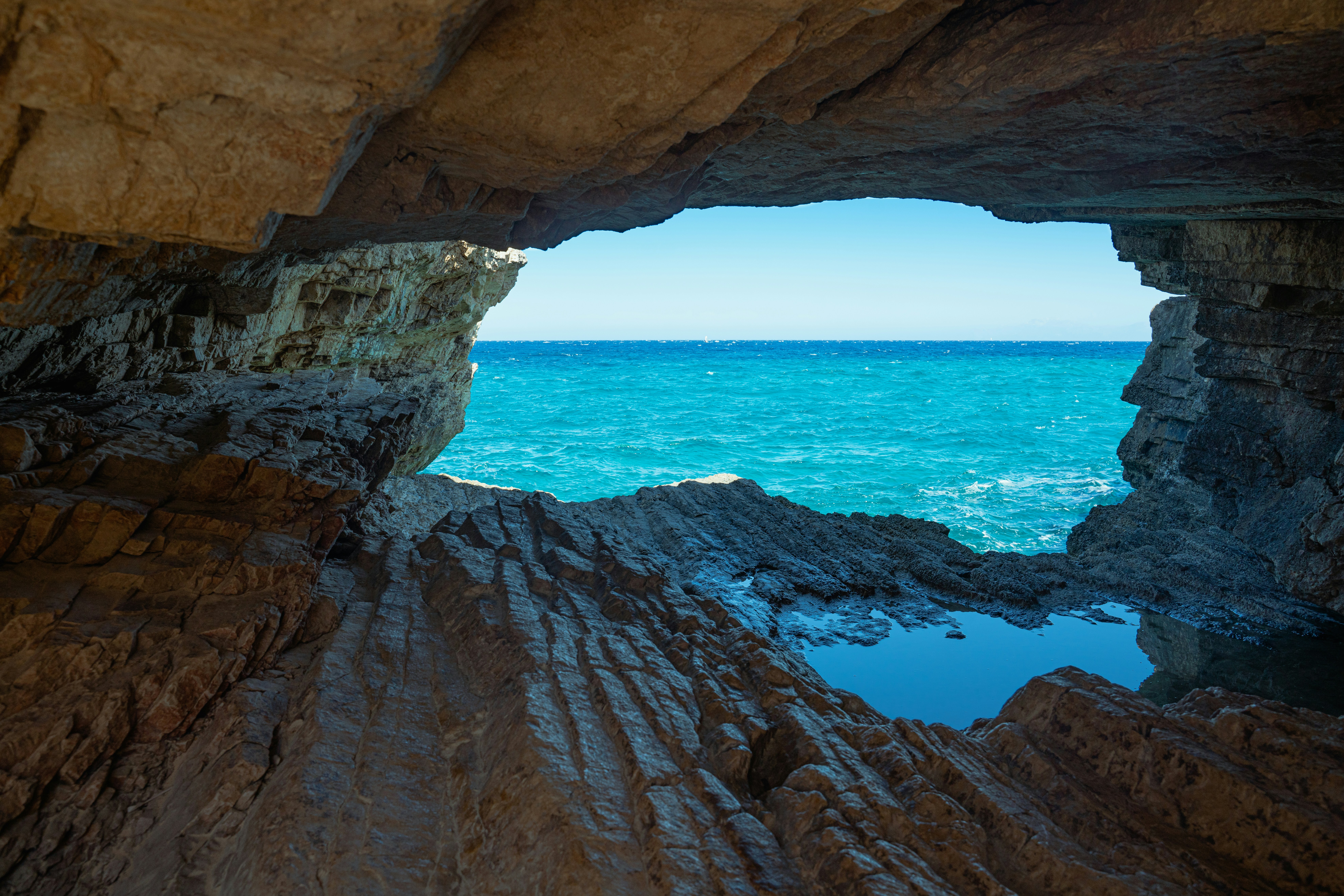 brown rock formation near blue sea during daytime, 