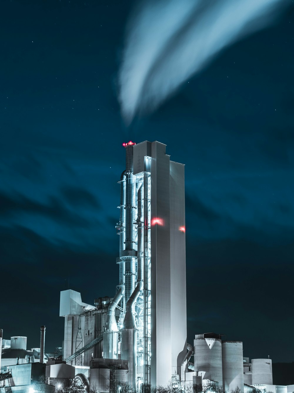 bâtiment en béton blanc et noir sous le ciel bleu pendant la nuit