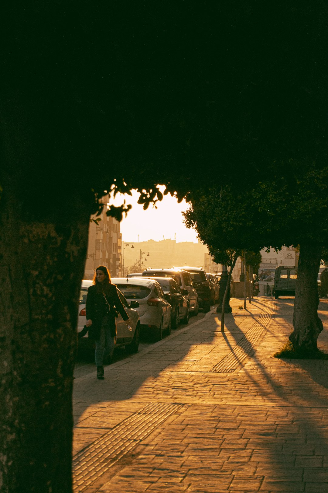 man in black coat walking on sidewalk during daytime