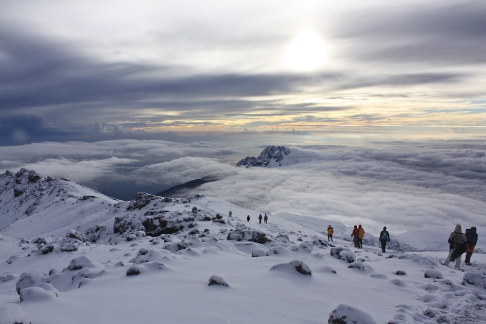 Gente en la montaña cubierta de nieve durante el día