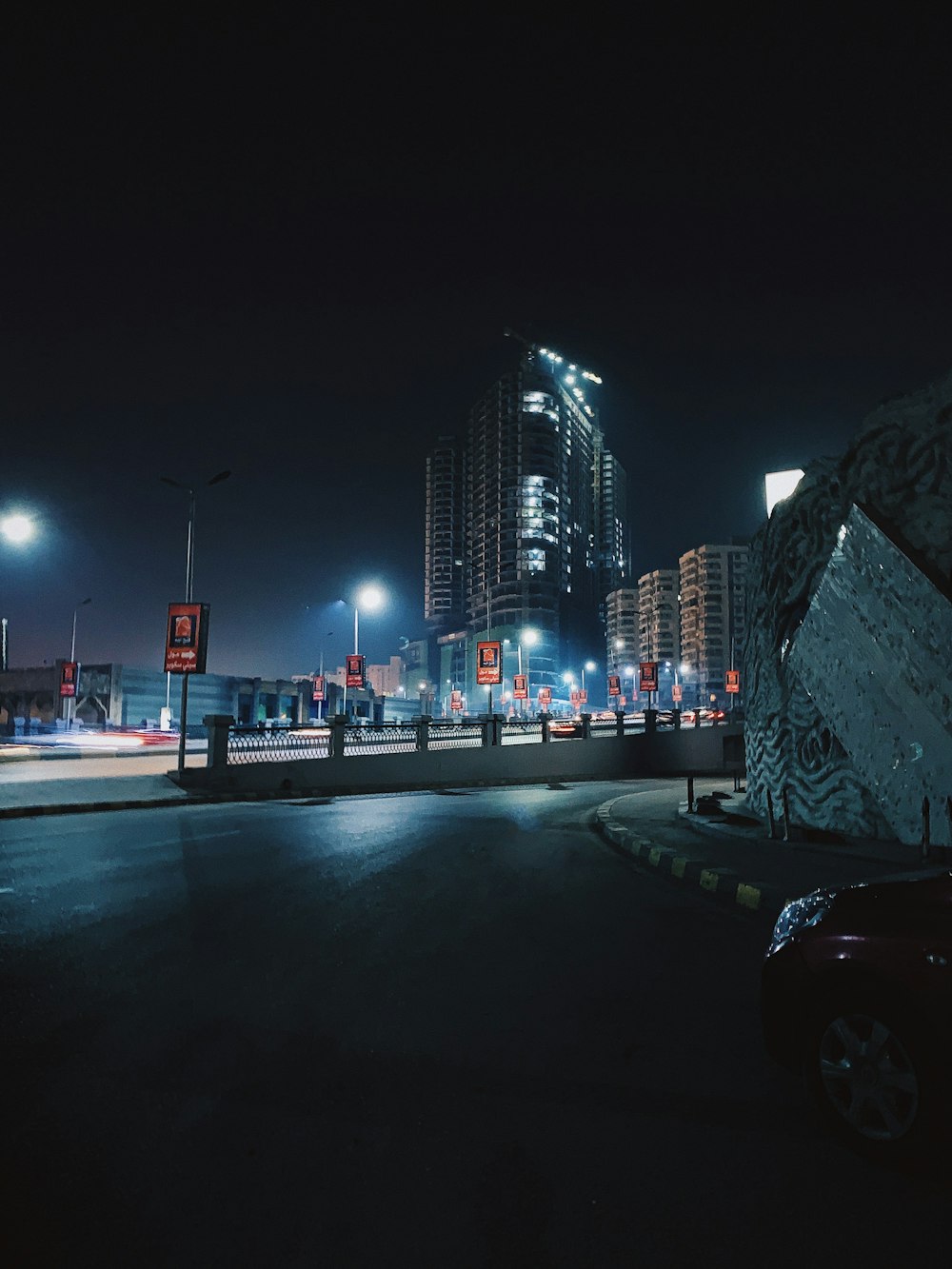 cars on road near city buildings during night time