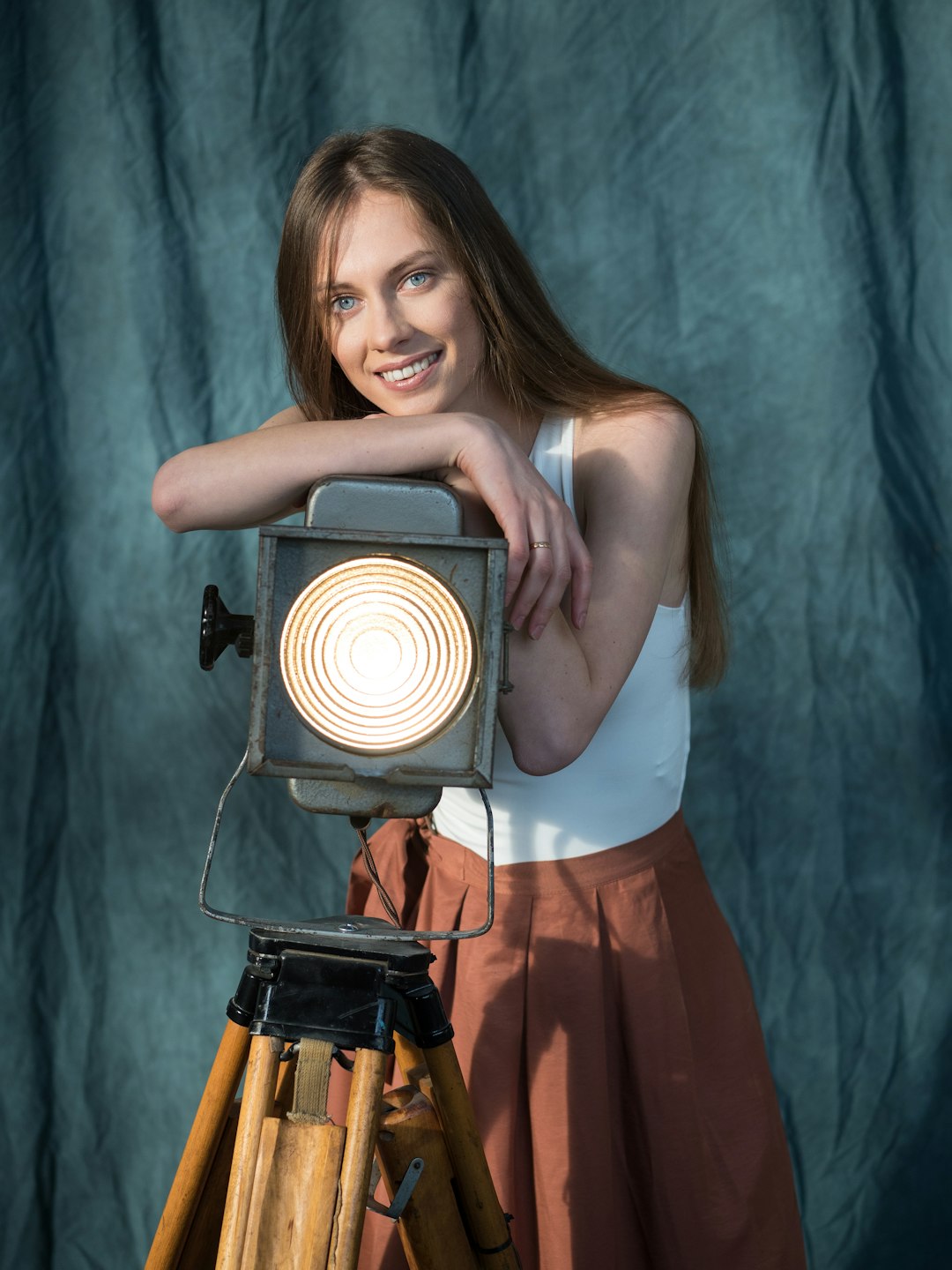 woman in white tank top and red skirt holding black and gray camera