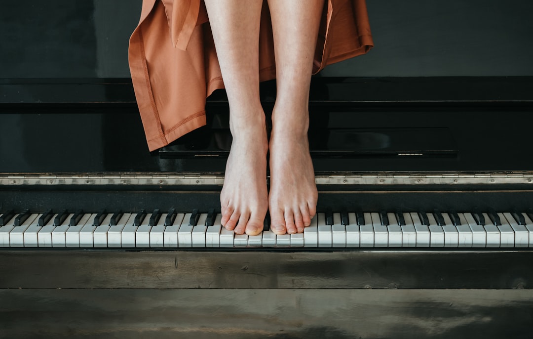 person in orange skirt standing on piano
