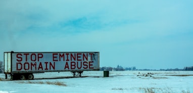 white and red wooden signage on snow covered ground during daytime