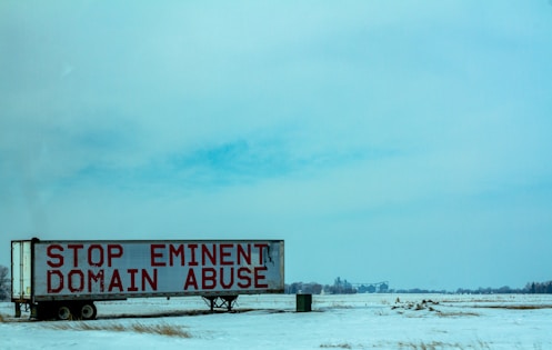 white and red wooden signage on snow covered ground during daytime