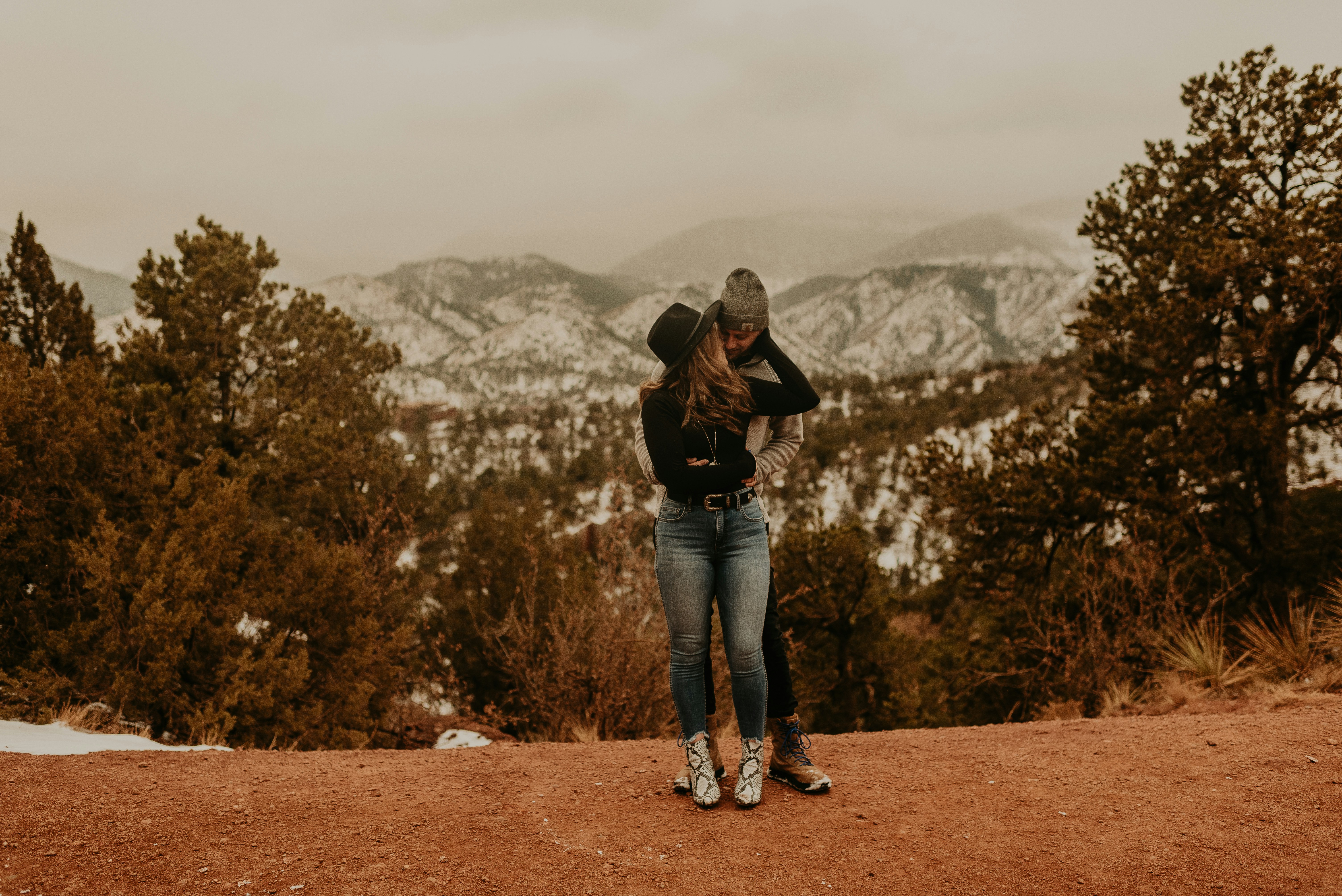 Woman in black jacket and blue denim jeans standing on brown field ...
