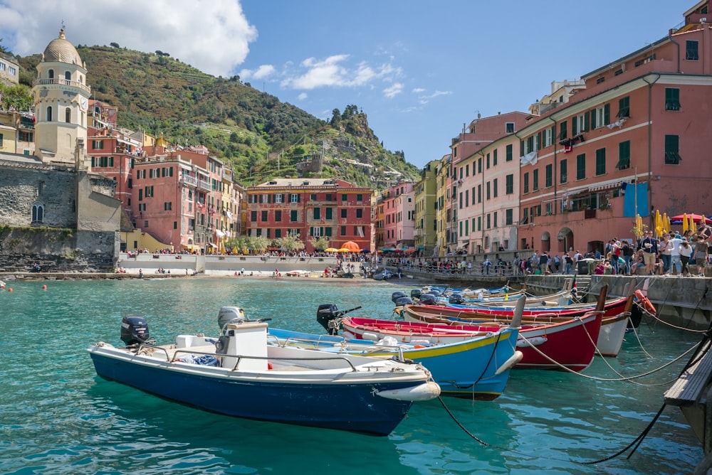 white and blue boat on water near buildings during daytime