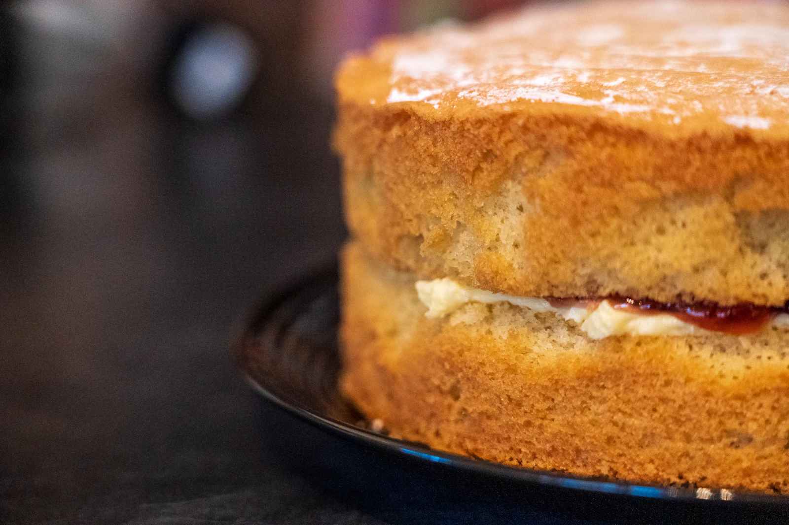 Génoise dorée et moelleuse garnie de crème et de confiture, sur un plat