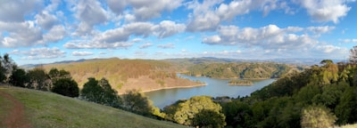 A panoramic view of a serene landscape with visible water sources and survey markers.