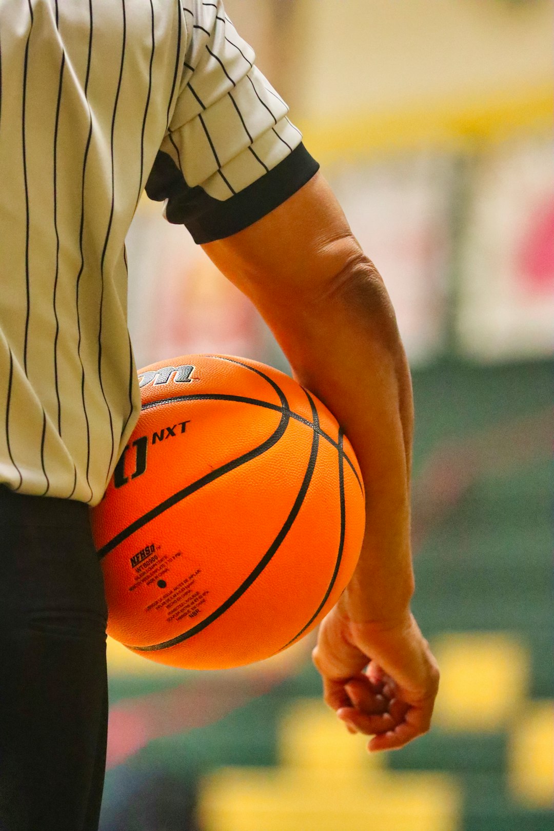 person holding brown basketball during daytime