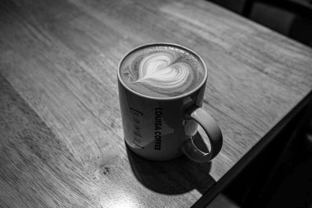 Foto in scala di grigi di tazza in ceramica con caffè