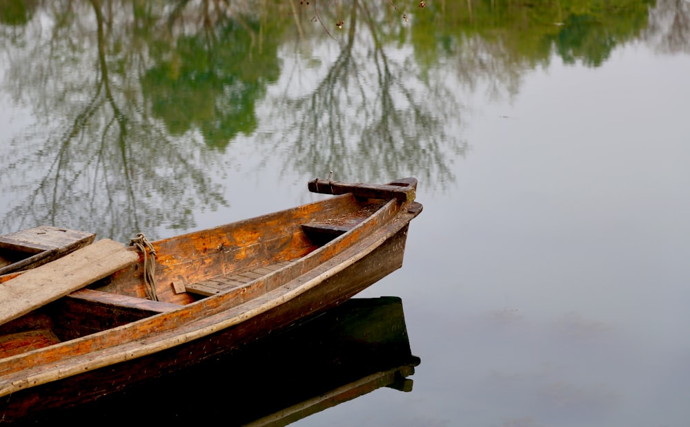 barco de madeira marrom no lago durante o dia