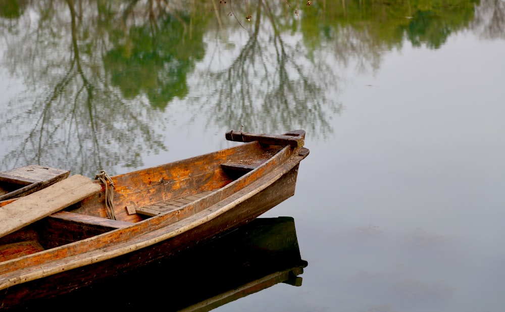 brown wooden boat on lake during daytime