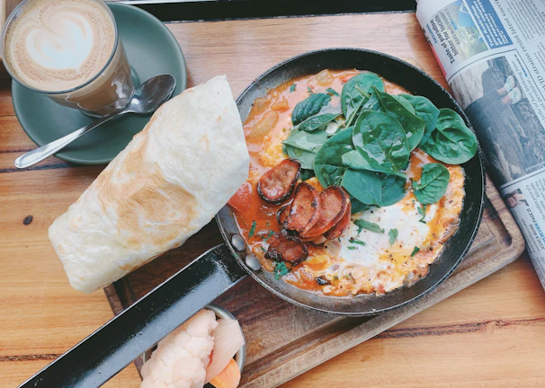 A cozy skillet breakfast with eggs, spinach, and roasted potatoes.